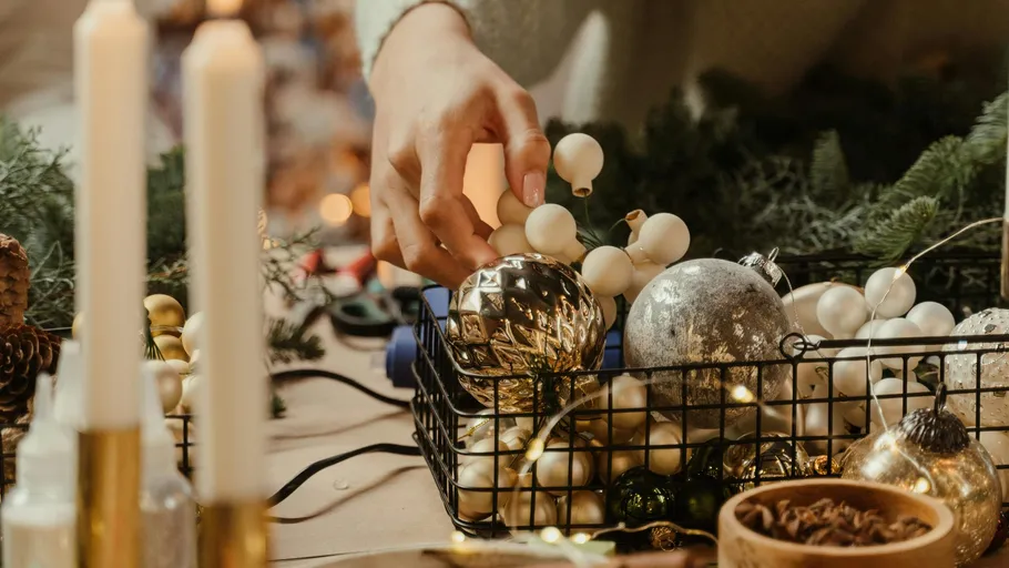 Hand arranging ornaments on festive table.