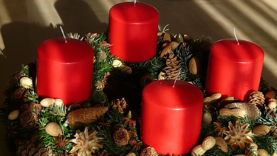 Rote Kerzen auf einem Adventskranz.