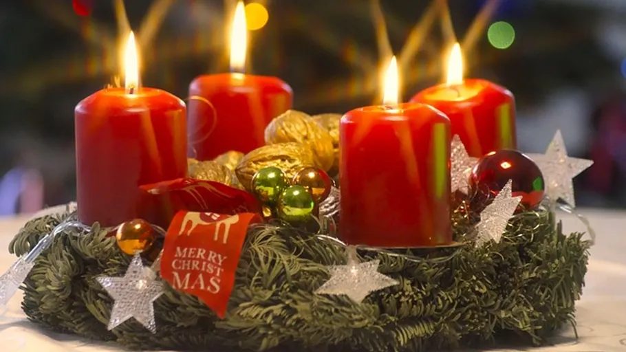 Rote Kerzen brennen auf Adventskranz.