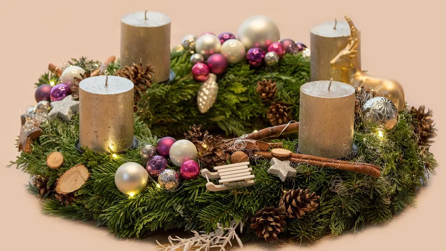 Adventskranz mit Kerzen und Dekorationen.