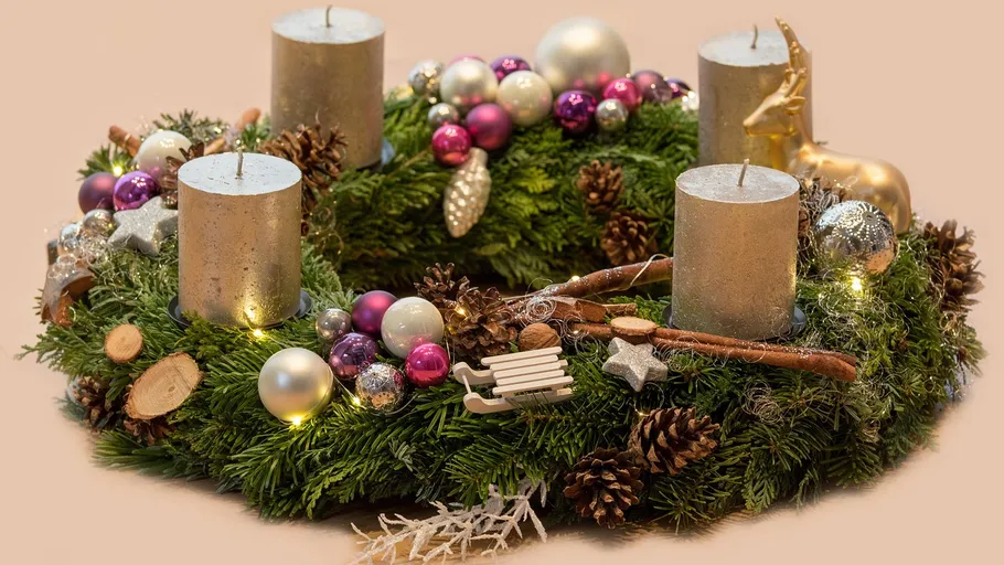 Adventskranz mit Kerzen und Dekorationen.