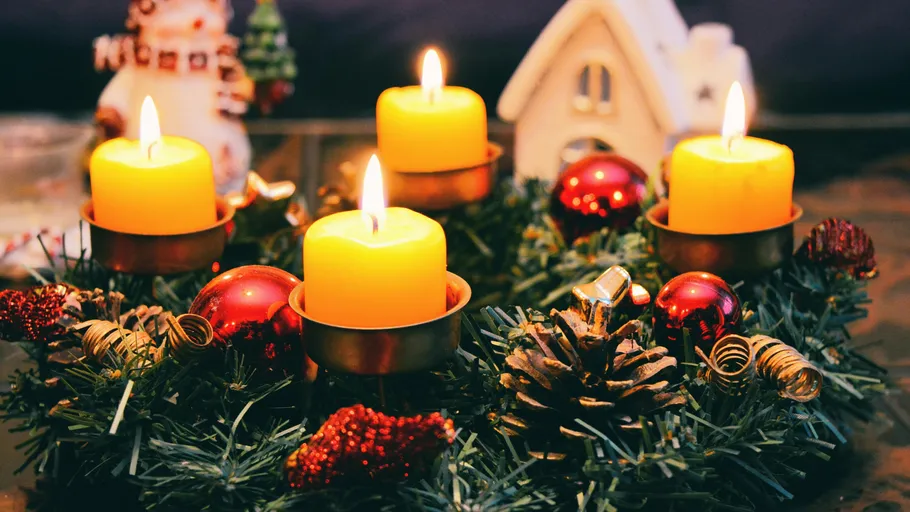 Kerzen auf Weihnachtskranz mit Dekorationen.
