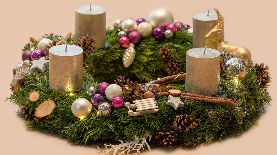 Adventskranz mit Kerzen und Ornamenten.