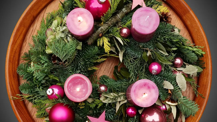 Weihnachtskranz mit Kerzen auf Holztablett.