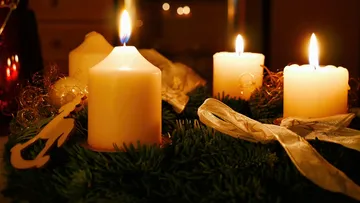 Lit candles on a decorated wreath.