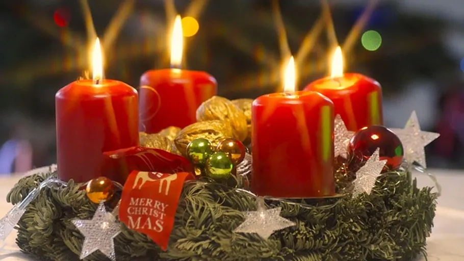 Rote Kerzen auf Adventskranz, bunte Lichter.