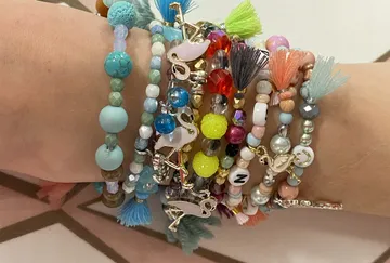 Bunte Armbänder am Handgelenk mit Flamingo-Anhängern.