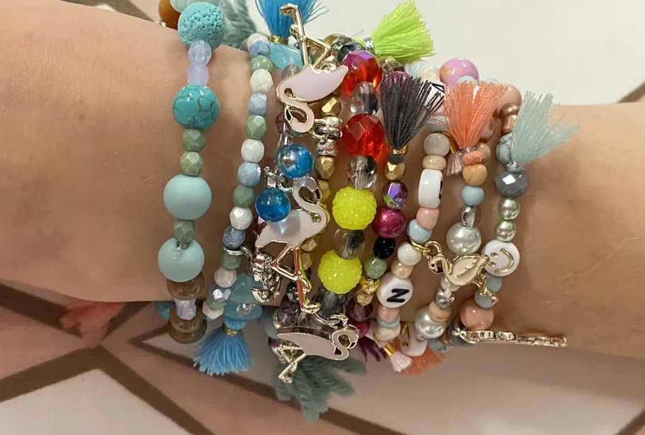 Bunte Armbänder am Handgelenk mit Flamingo-Anhängern.