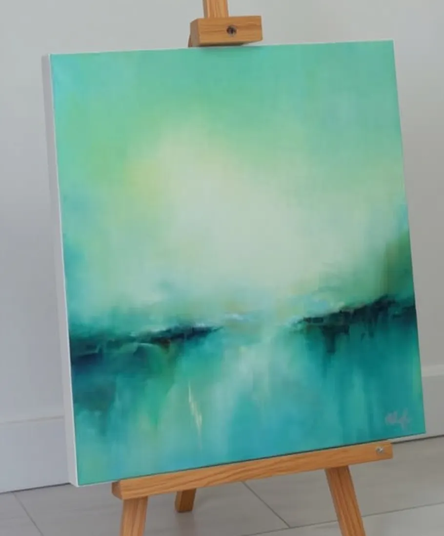 Abstract painting on easel in bright room.