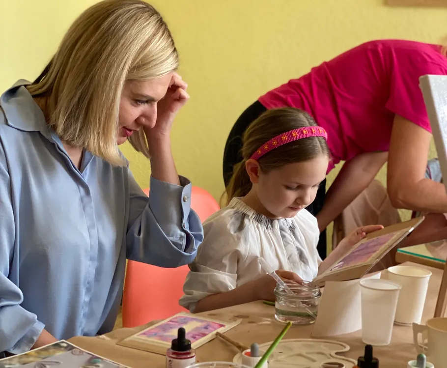 Woman and girl painting in an art class.