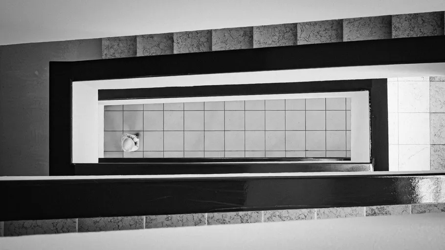 Stairwell viewed from above, tiled floor visible.