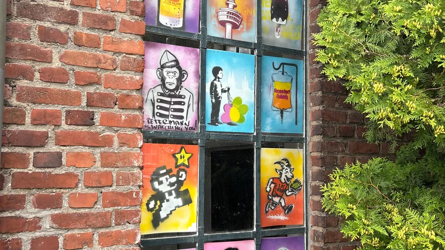 Bunte Straßenkunst an einer Ziegelwand.