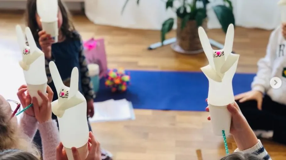 Kinder halten selbstgemachte Hasen-Bastelarbeiten drinnen.