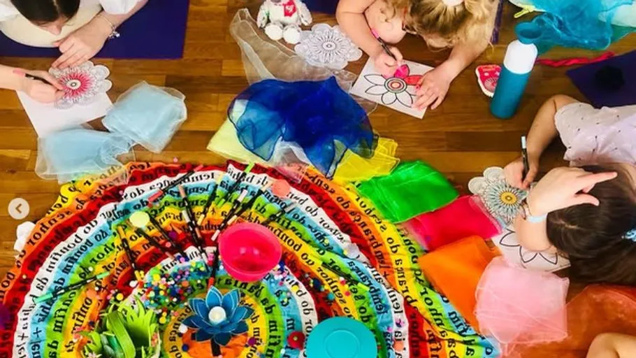 Children coloring mandalas on wooden floor.