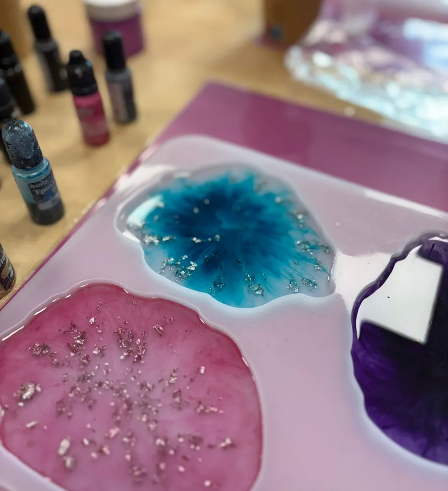 Epoxy resin art with colored inks on table.
