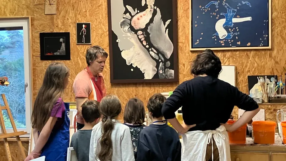Kunstlehrer unterrichtet Kinder im Atelier.