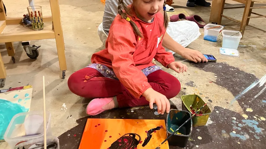 Child painting on floor in art class.