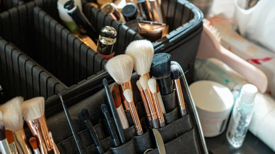 Make-up-Pinsel und Kosmetik in organisiertem Etui.