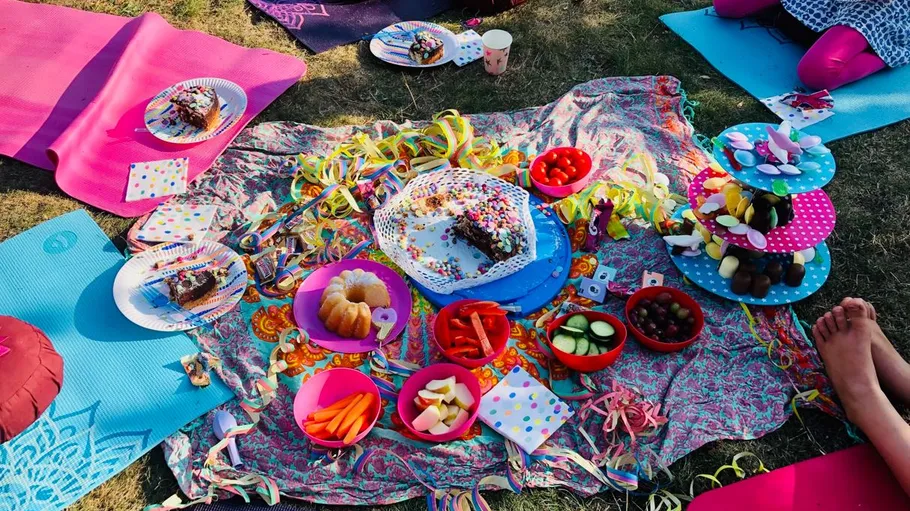 Geburtstagspicknick mit bunten Snacks auf Gras.