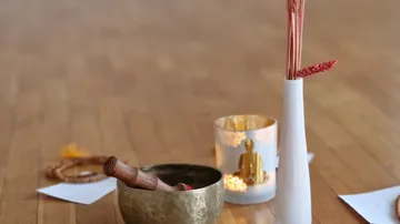 Tibetan bowl and vase on wooden floor.