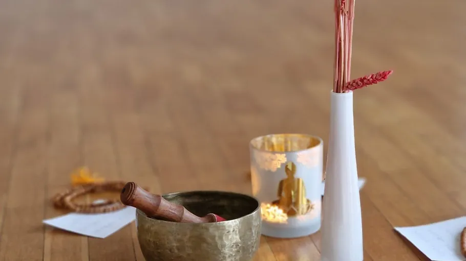 Tibetan bowl and vase on wooden floor.