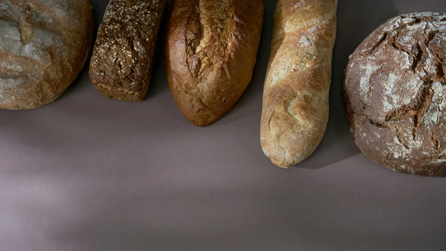 Five different breads on a table surface.