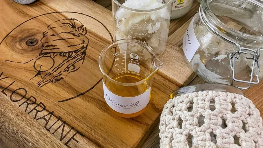 Messglas mit Olivenöl auf Holzbrett.
