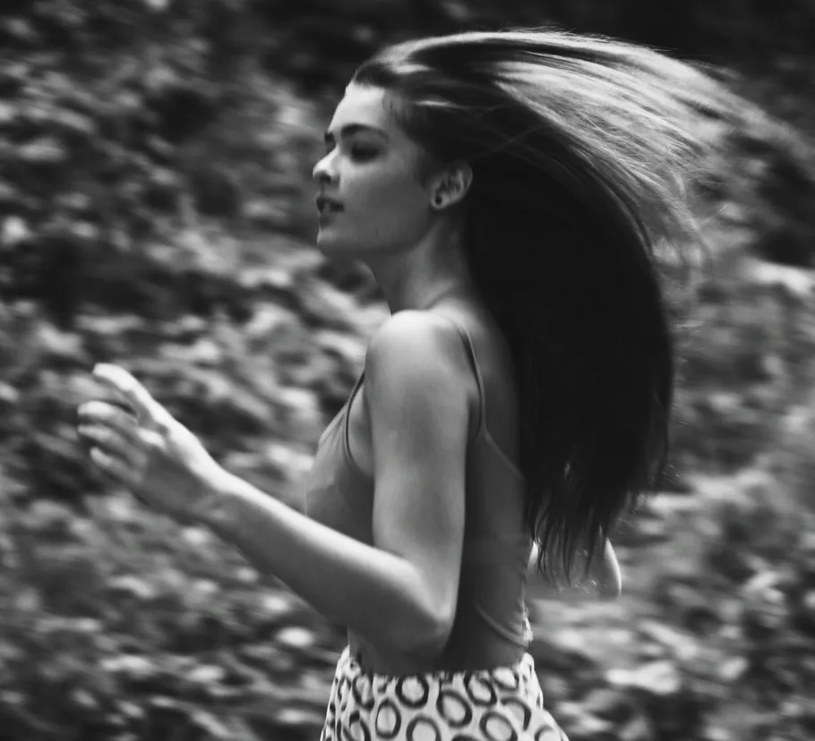 Woman running with flowing hair outdoors.
