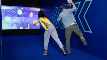Two people playing interactive ball game.