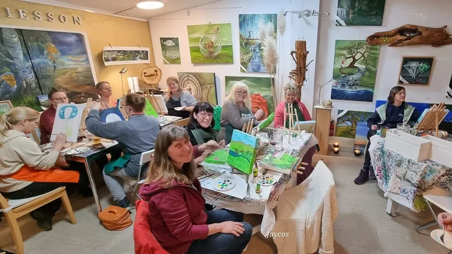 Group of people painting in an art studio.