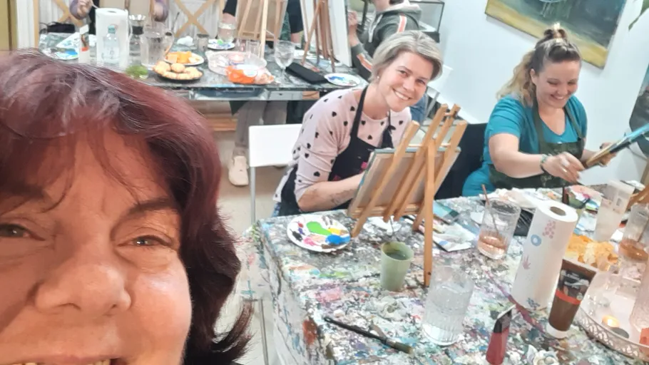 People painting at a workshop with smiles.