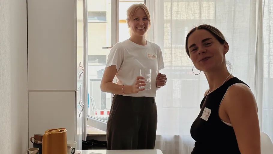 Zwei Frauen lächeln in heller Küche.