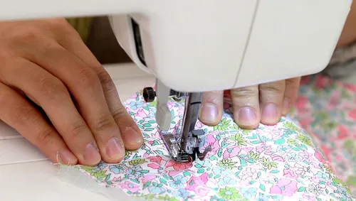 Sewing machine stitching floral fabric.