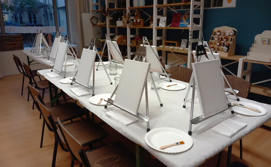 Leeres Kunststudio mit Staffeleien und Stühlen.