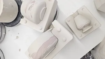 Keramikformen mit Ton auf einem Tisch.
