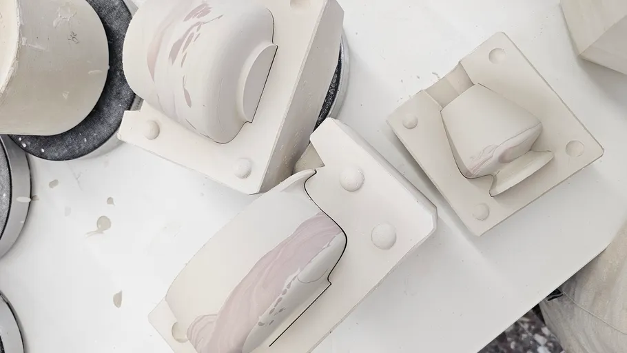 Ceramic molds with clay on a table.