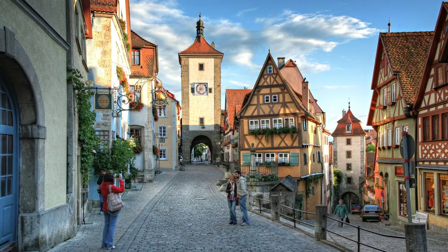 Tourists photographing historical cobblestone street, Rothenburg ob der Tauber.