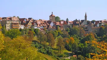 Medieval town on hill with trees.