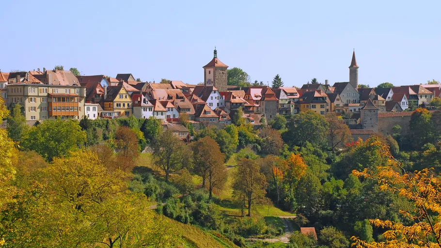 Medieval town on hill with trees.