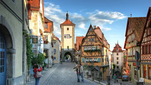 Tourists photographing medieval town street scene.