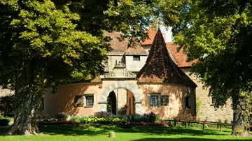 Kleines Burgtor, von Bäumen umgeben, sonniger Tag.