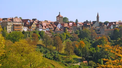 Medieval town with towers and autumn trees.