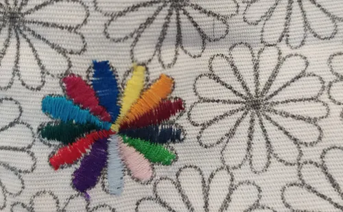 Bunte Stickerei auf blumengemustertem Stoff.