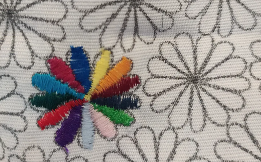 Bunte Stickerei auf blumengemustertem Stoff.