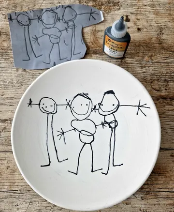 Kinderzeichnung auf Papier und Teller.
