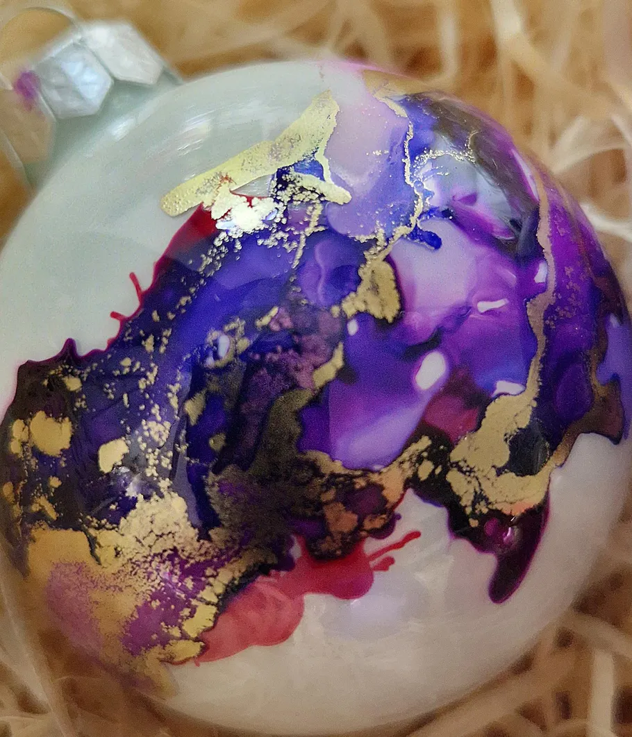 Glass ornament with purple and gold patterns.
