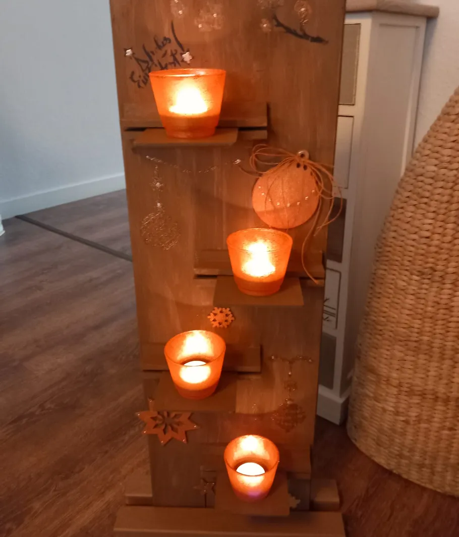 Candles on wooden stand with decorations.