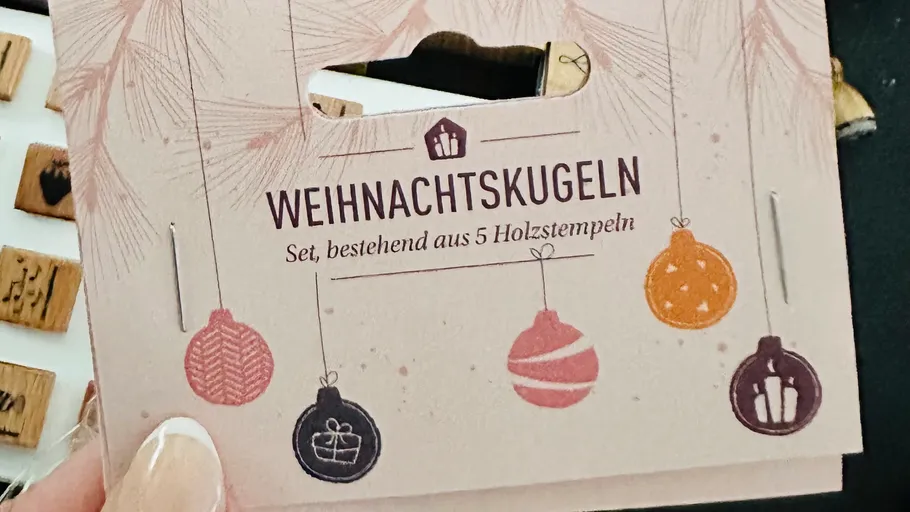 Hand hält Karte mit Weihnachtsdeko-Design.