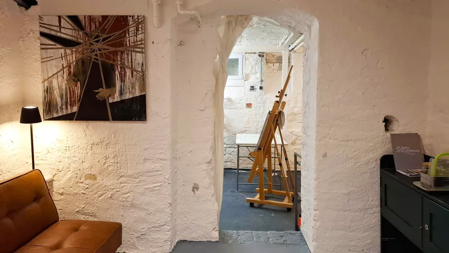 Cozy basement art studio with painting and easel.