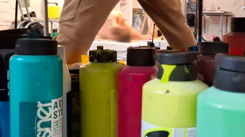 Paint bottles on floor in art studio.